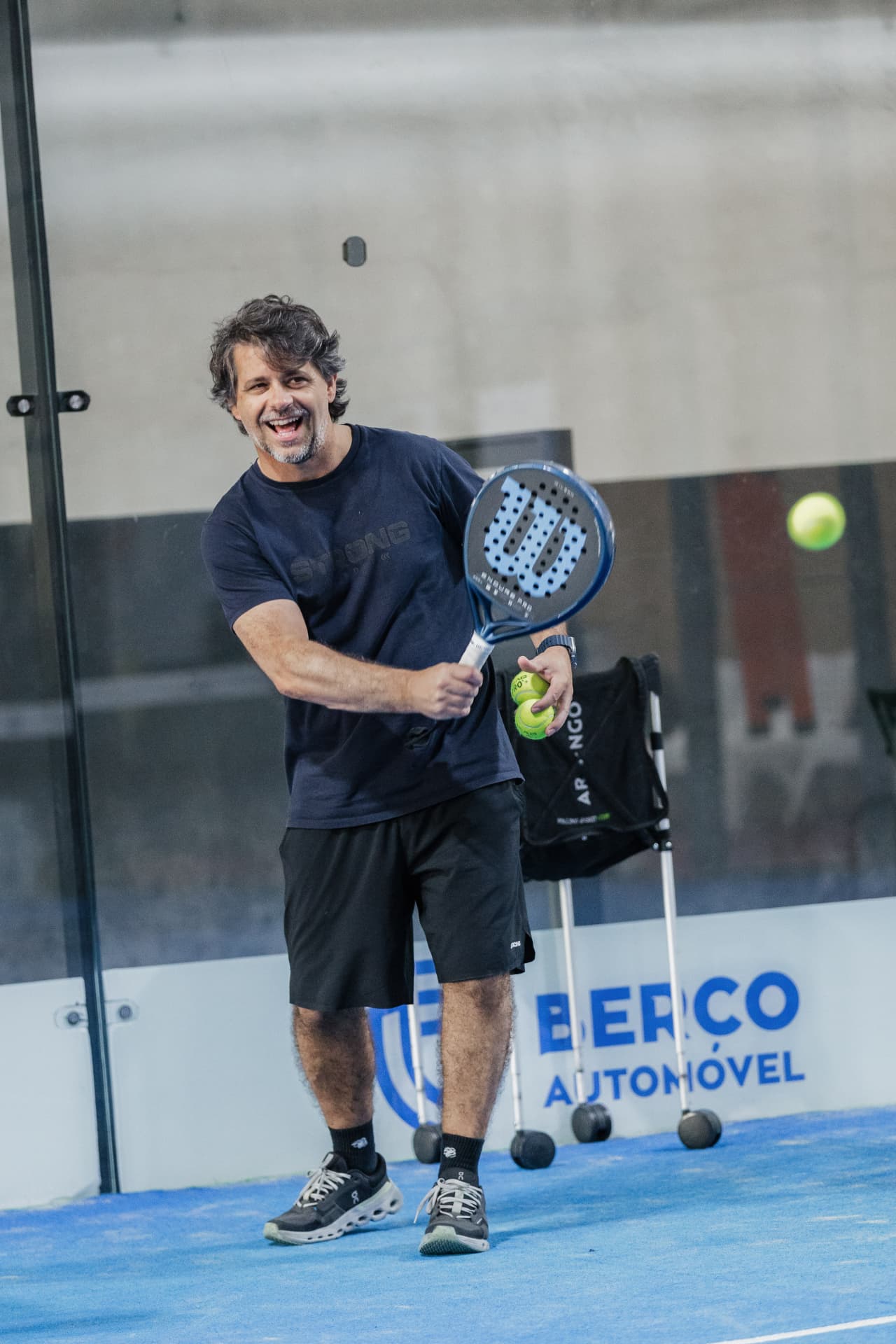 Jogador a rir durante um treino de padel